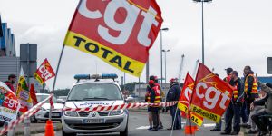 Workers and General Confederation of Labour ("Confederation generale du travail", CGT) unionists talk to policemen as they block the access road to the Rubis terminal oil depot on May 21, 2016, in Dunkirk. Several oil depots are blocked on May 21 in the Nord-Pas-De-Calais former region by demonstrators protesting against the labour reform law. / AFP PHOTO / PHILIPPE HUGUEN