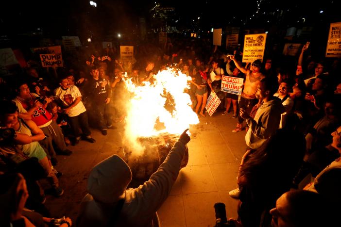 A Donald Trump pinata is burned by people protesting the election of Republican Donald Trump as the president of the United States in downtown Los Angeles, California U.S., November 9, 2016.   REUTERS/Mario Anzuoni